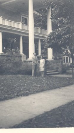 Miller+woman in front of house