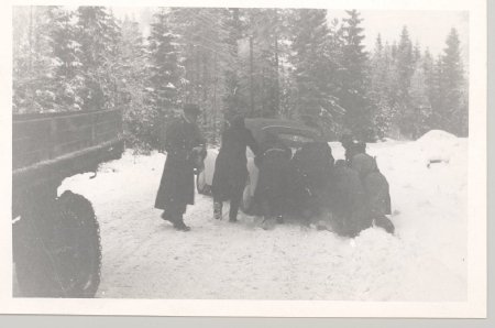 men pushing car out of snow