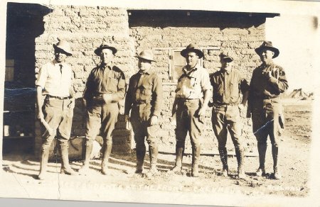 six men in front of house