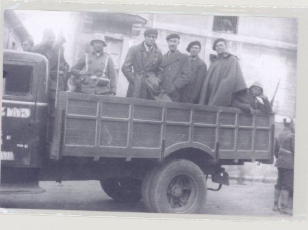 men standing in back of truck